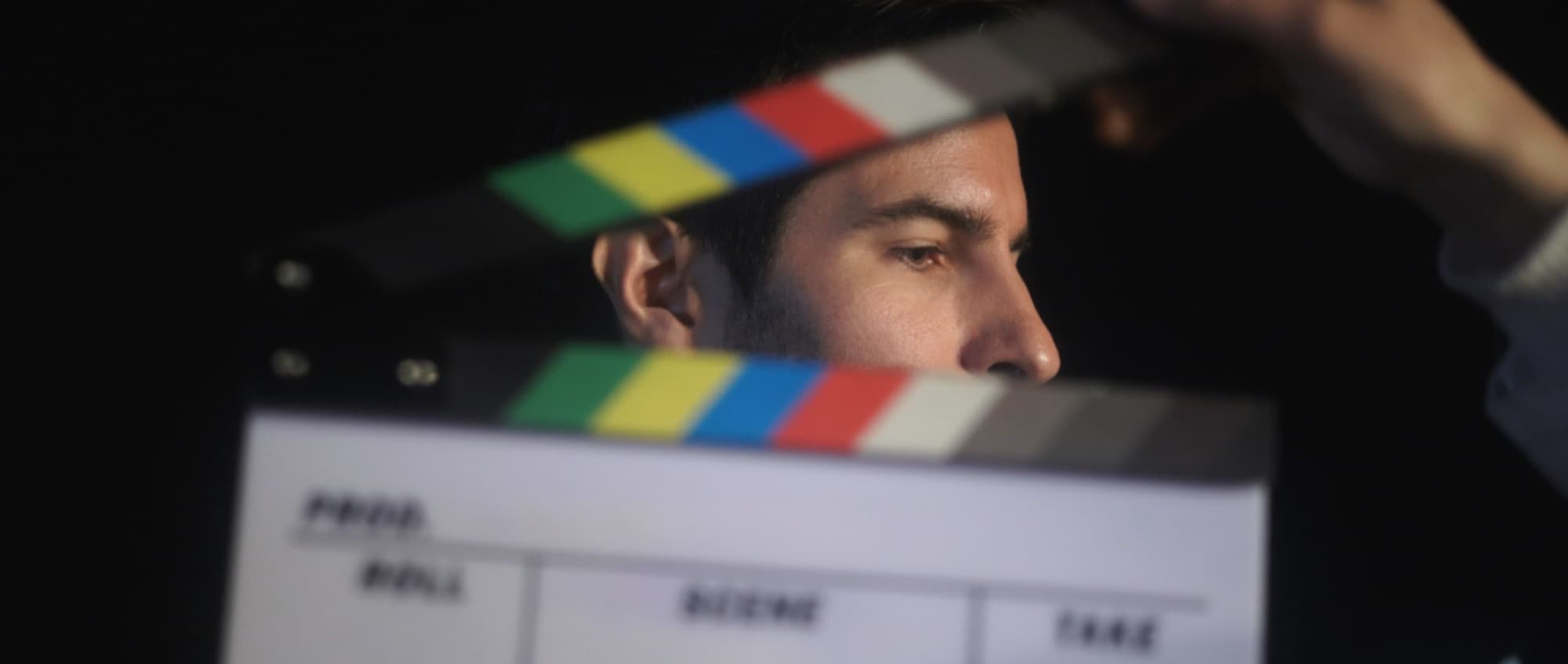 Un comédien derrière le clap, juste avant une prise